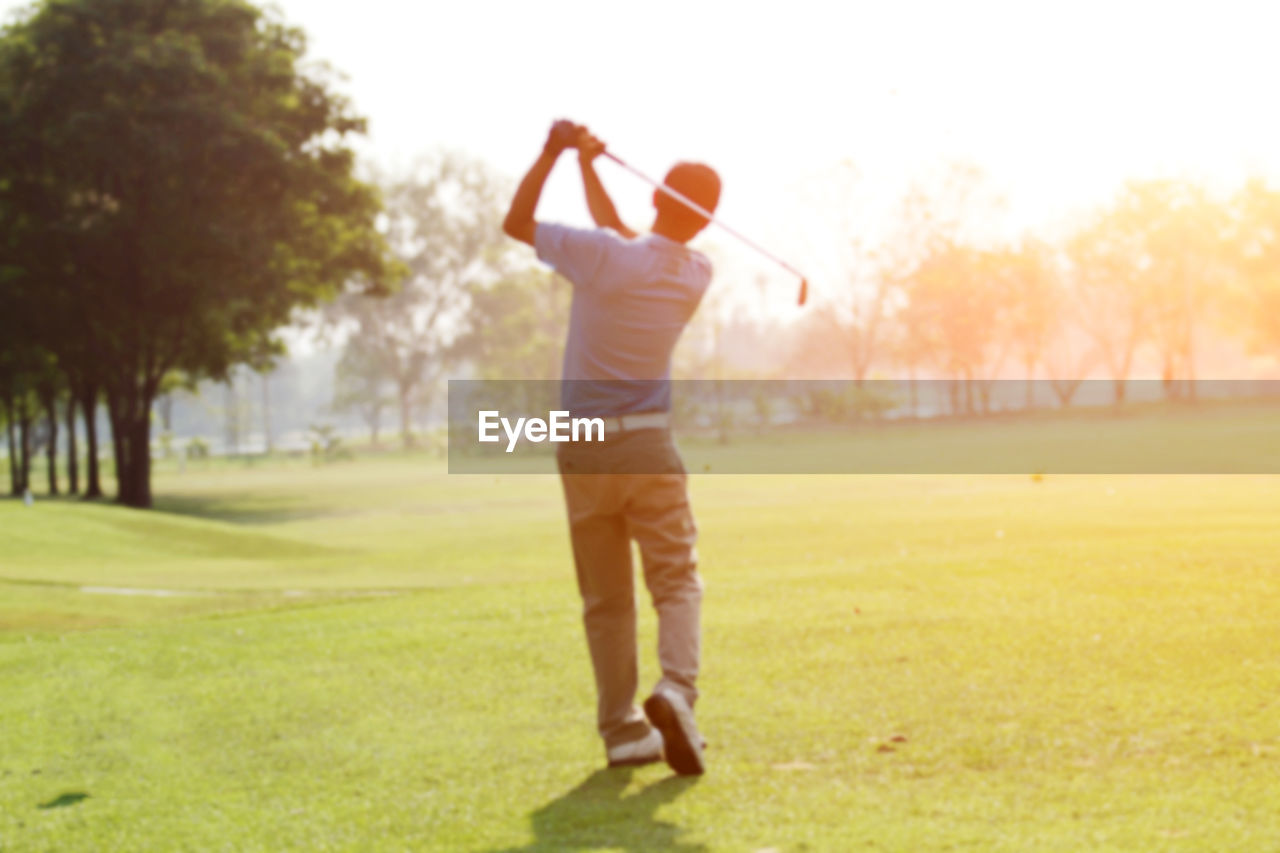 Rear view of man playing golf