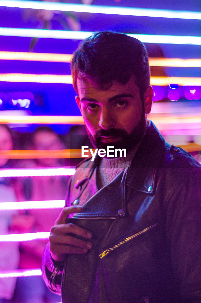 Portrait of bearded young man wearing leather jacket in nightclub