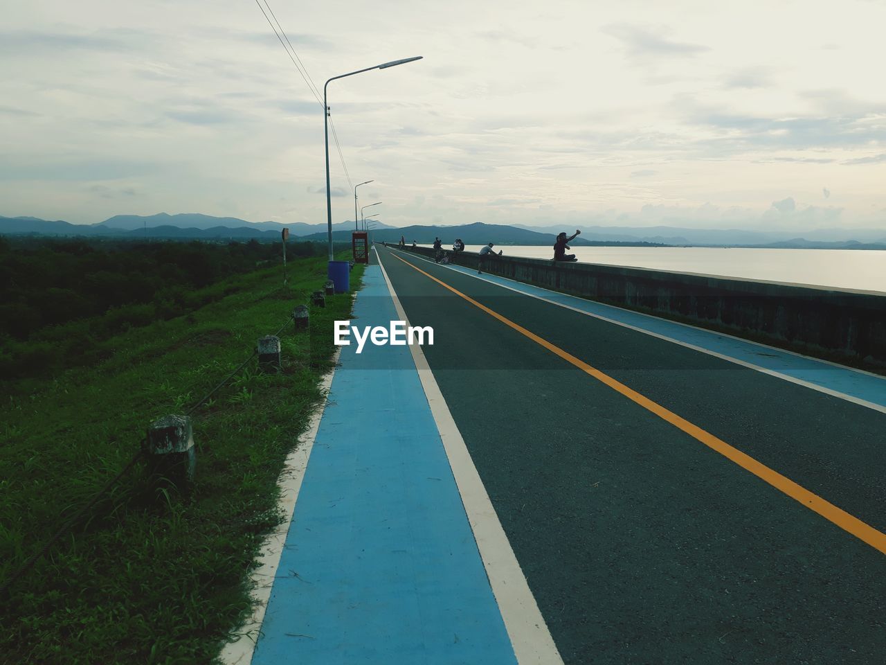 Empty road against cloudy sky