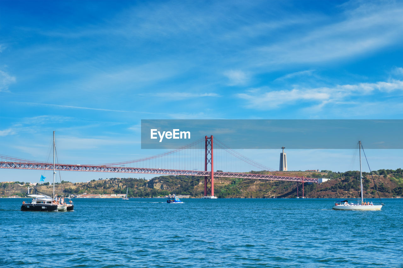 view of suspension bridge over sea against sky