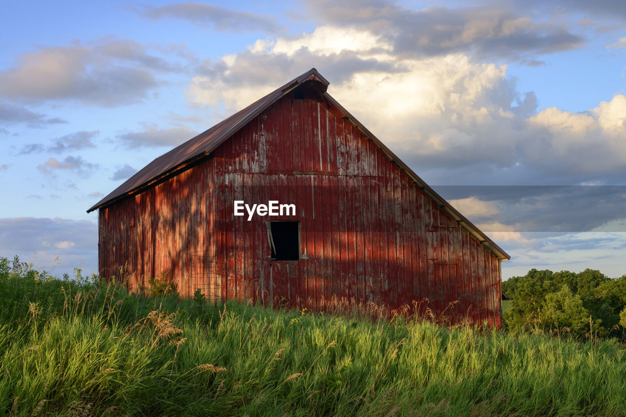 BARN ON FIELD AGAINST SKY