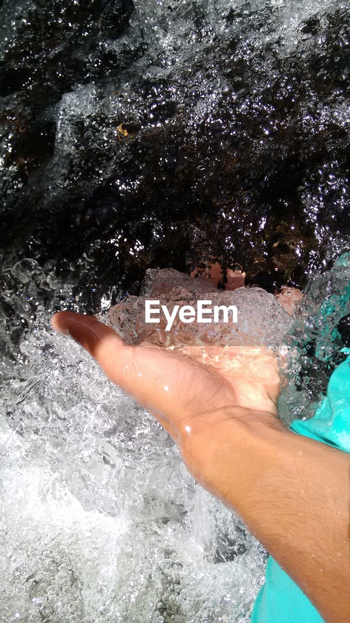 LOW SECTION OF PERSON RELAXING IN WATER