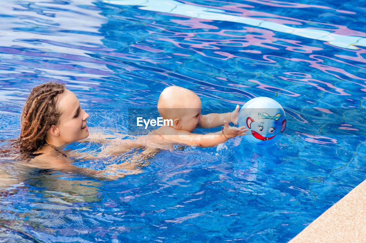 Woman with baby boy swimming in pool