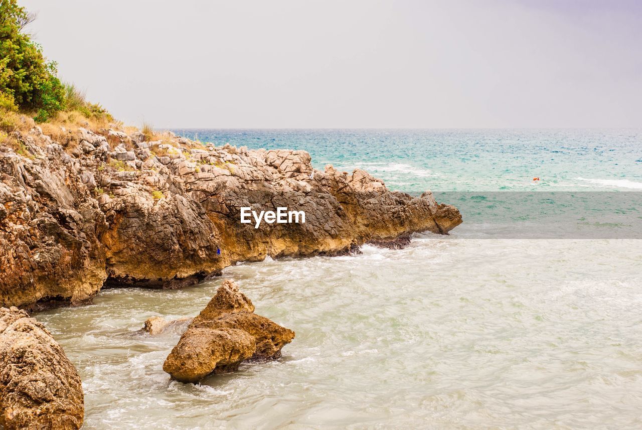 Rocks on beach against sky