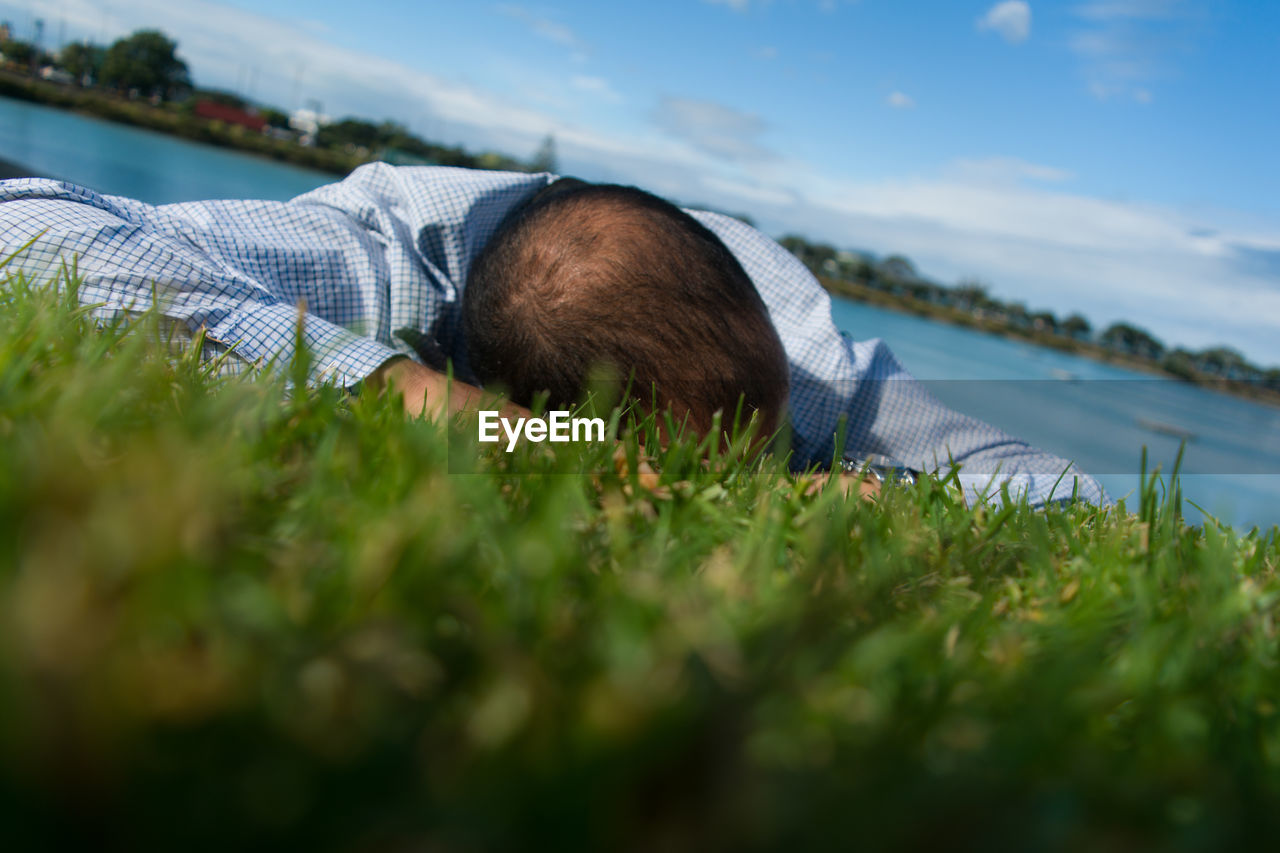 Surface level view of man lying on grassy field