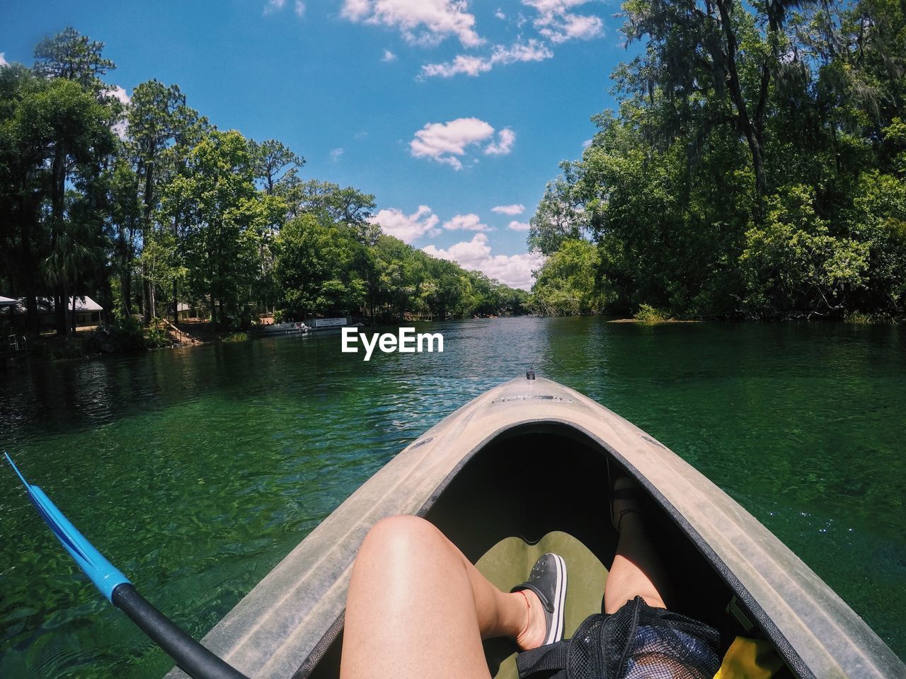 Low section of woman in river against sky