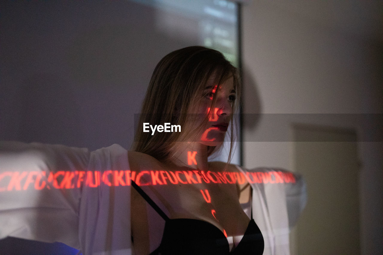 Young woman with illuminated text at home