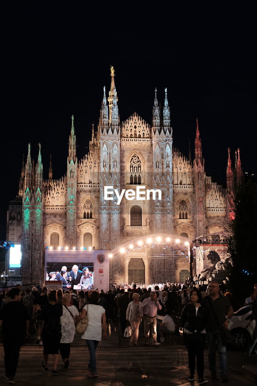 People in front of illuminated milan cathedral at night