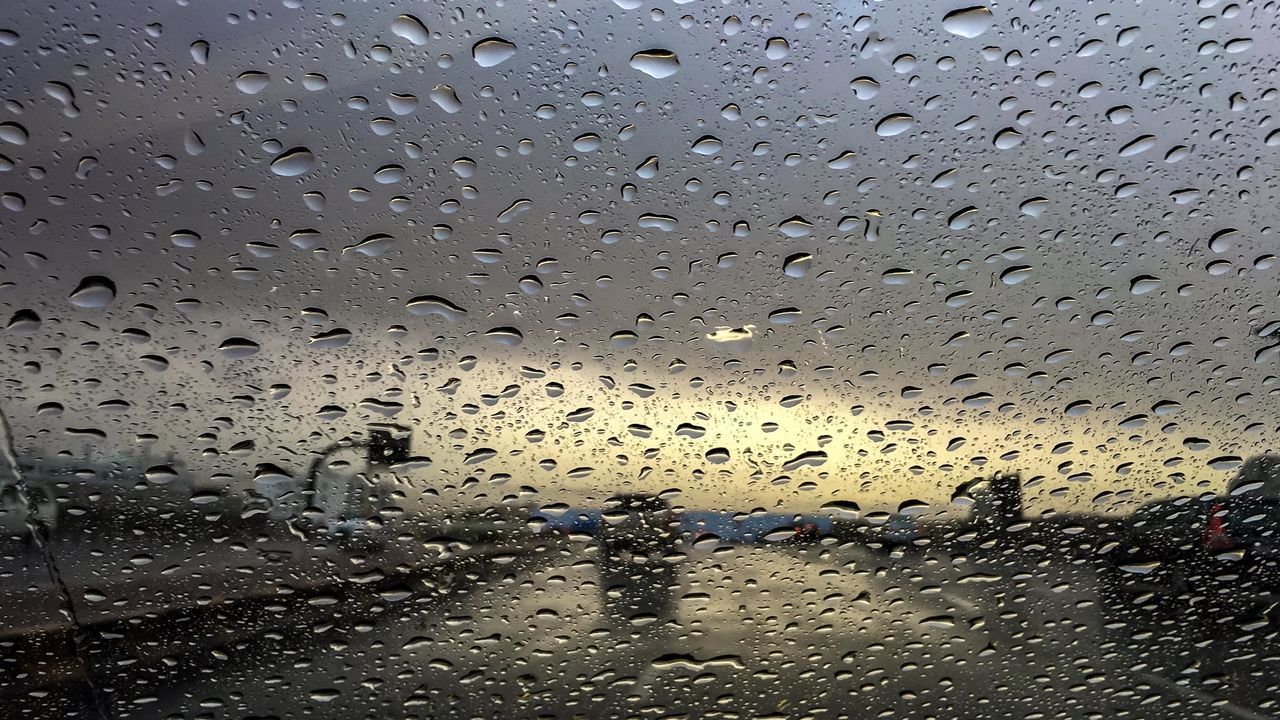 CLOSE-UP OF WET WINDOW AGAINST SKY