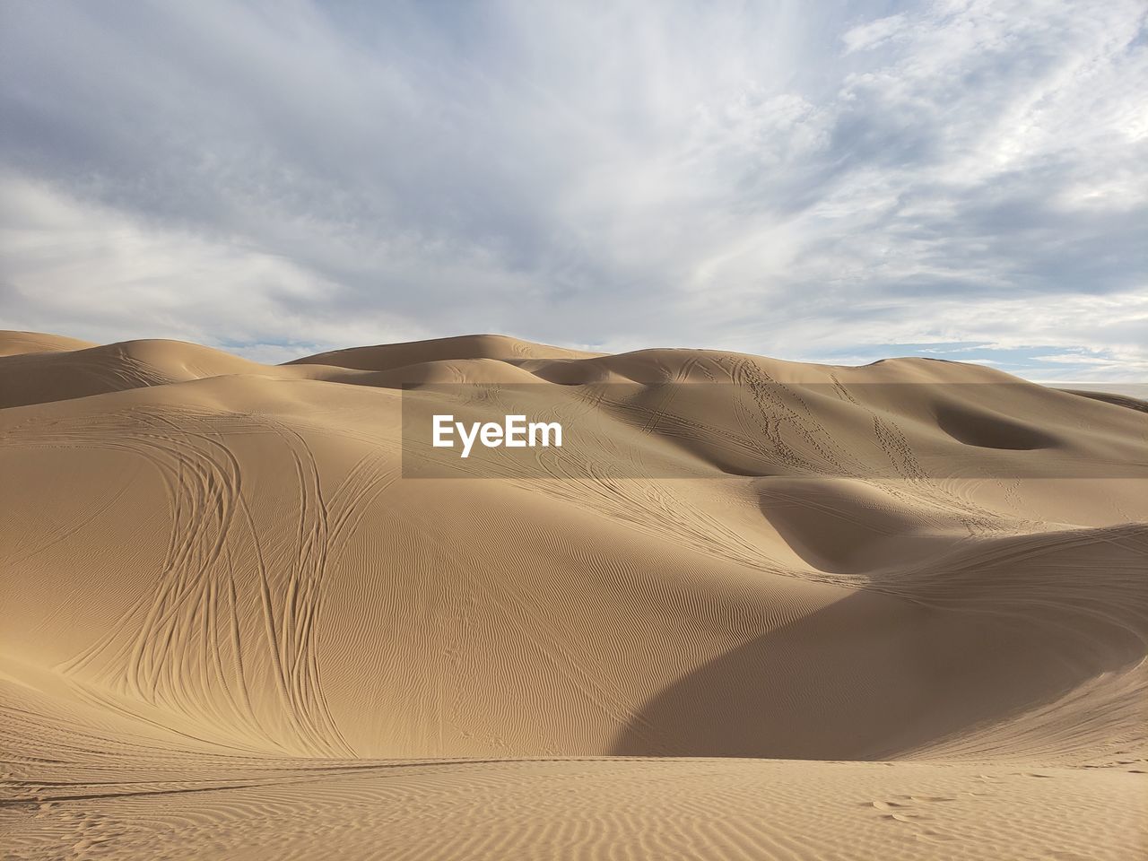 Sand dunes in desert against sky