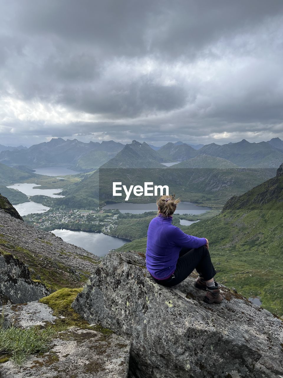 rear view of man standing on mountain against sky