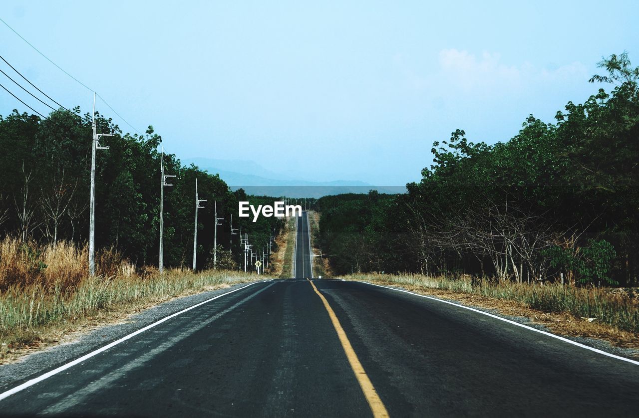 Diminishing perspective of empty road against sky