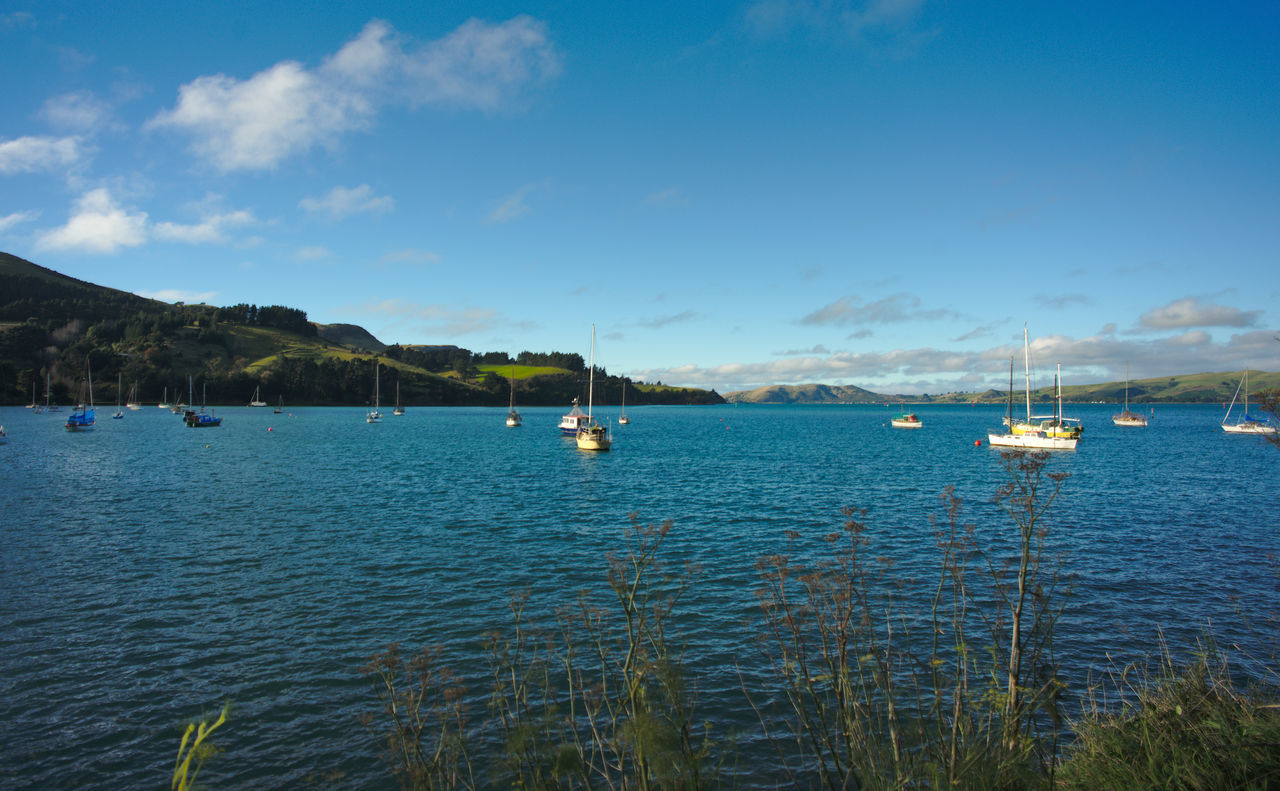 Boats sailing in sea against sky