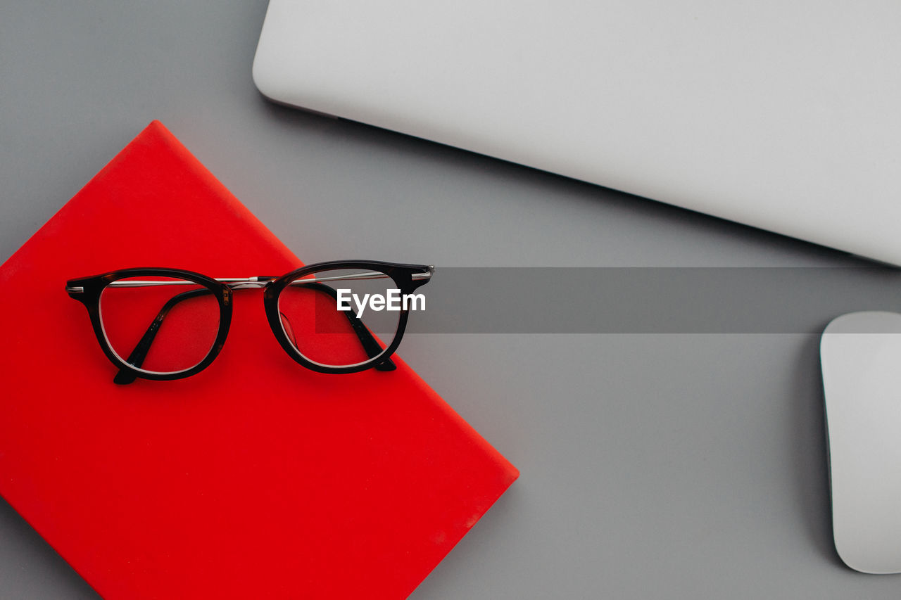 eyeglasses, glasses, red, indoors, no people, eyewear, vision care, business, office, table, font, still life, close-up, studio shot, communication, paper, technology, desk, wireless technology, furniture