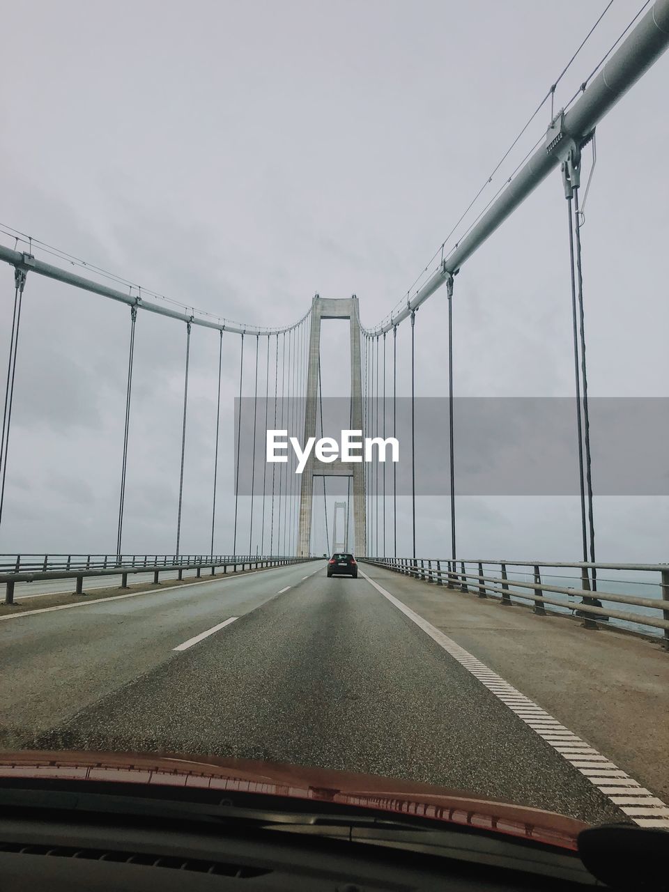 Bridge against sky seen through car windshield