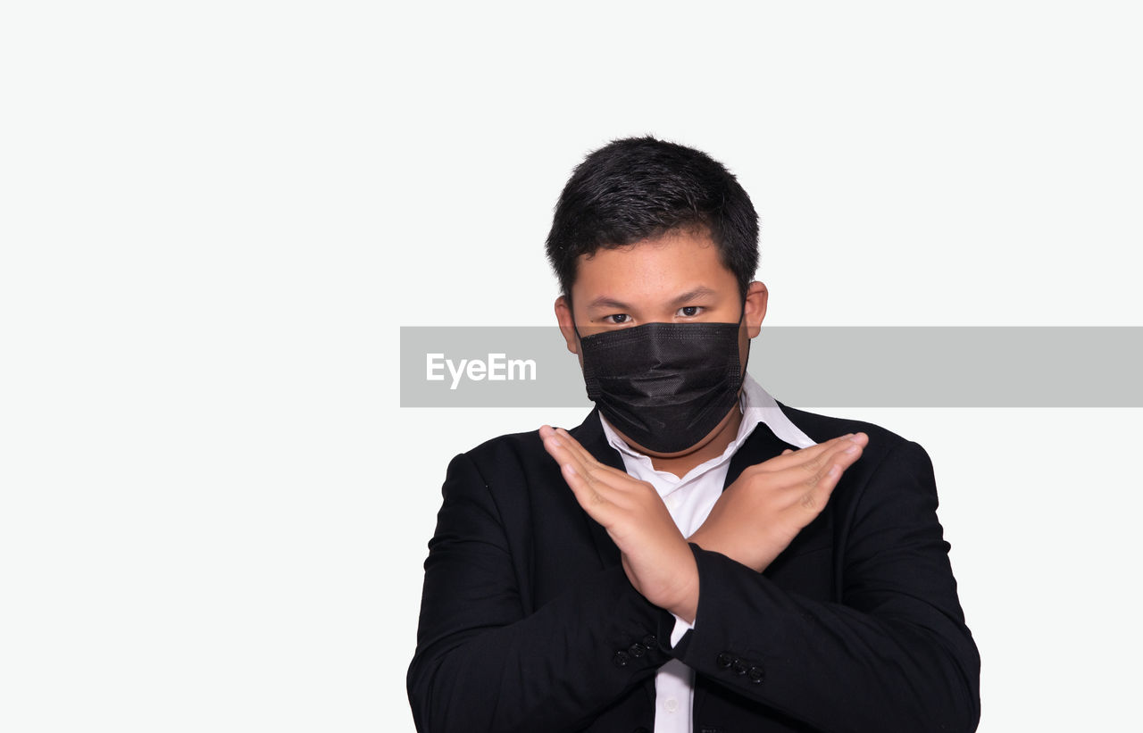 PORTRAIT OF MAN STANDING AGAINST WHITE BACKGROUND