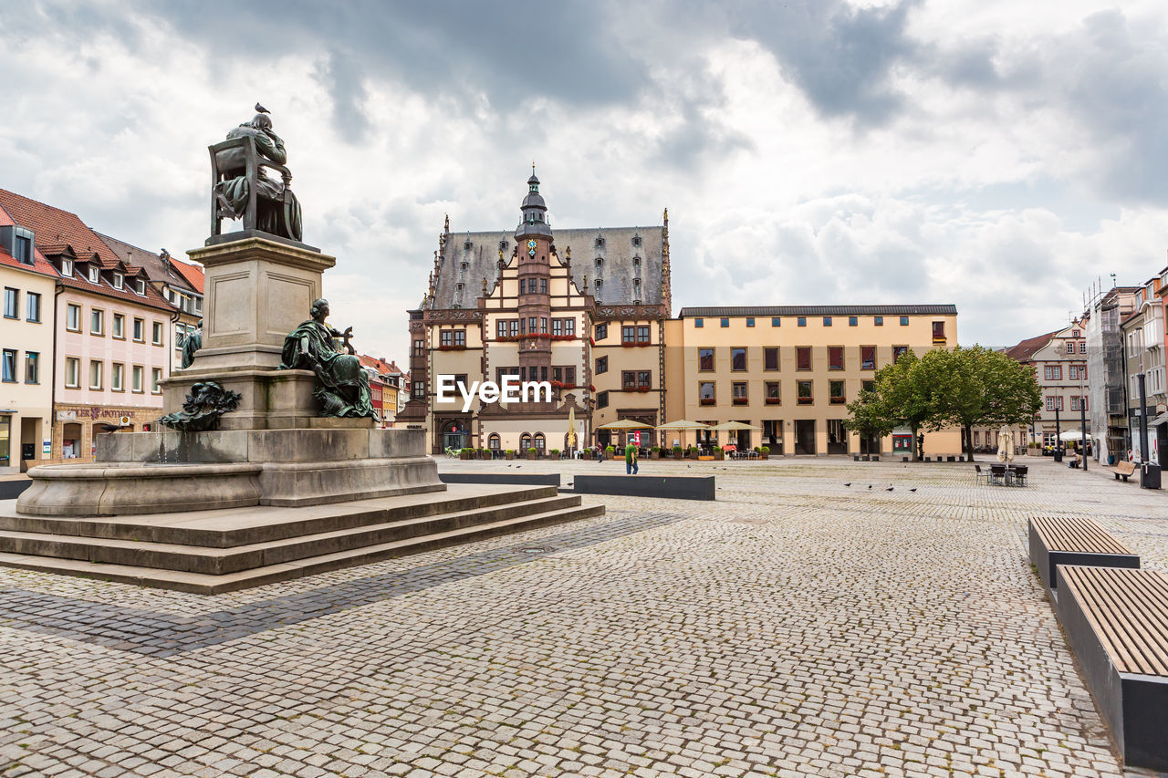 STATUE BY STREET AGAINST BUILDINGS IN CITY