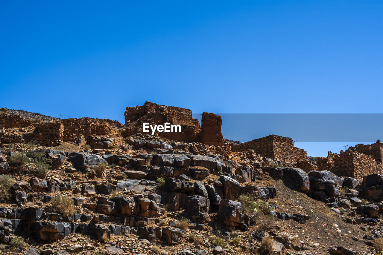 sky, rock, nature, blue, clear sky, mountain, travel destinations, landscape, travel, scenics - nature, environment, no people, land, ruins, rock formation, architecture, history, sunny, outdoors, beauty in nature, non-urban scene, the past, terrain, ancient history, ancient, geology, tourism, tranquility, cliff, day, built structure, copy space, plateau