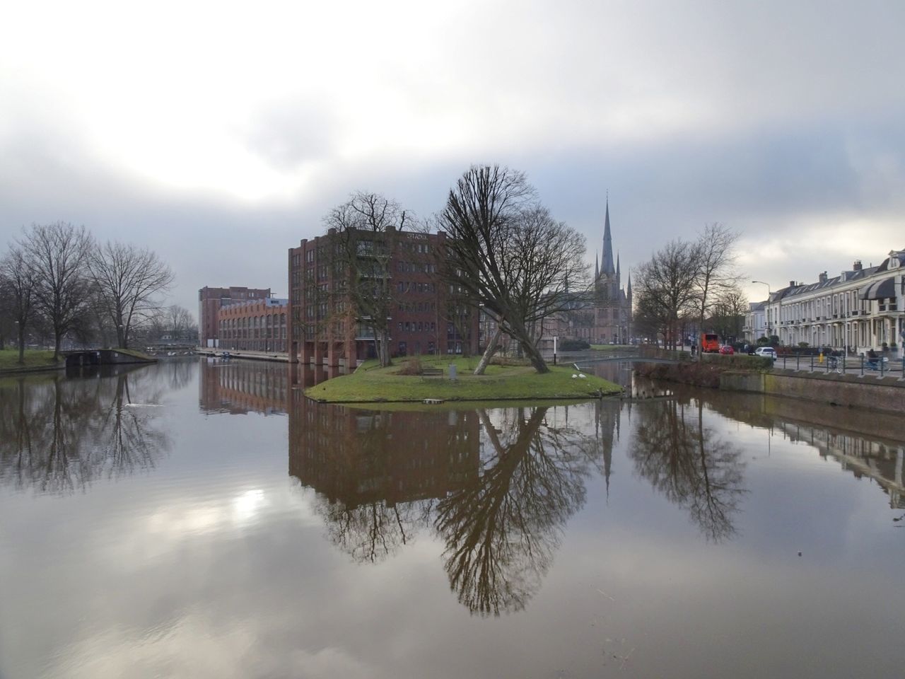 REFLECTION OF BUILDINGS IN RIVER AGAINST SKY