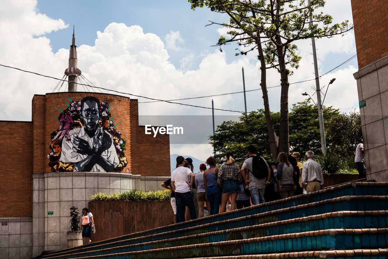 GROUP OF PEOPLE IN FRONT OF BUILDINGS