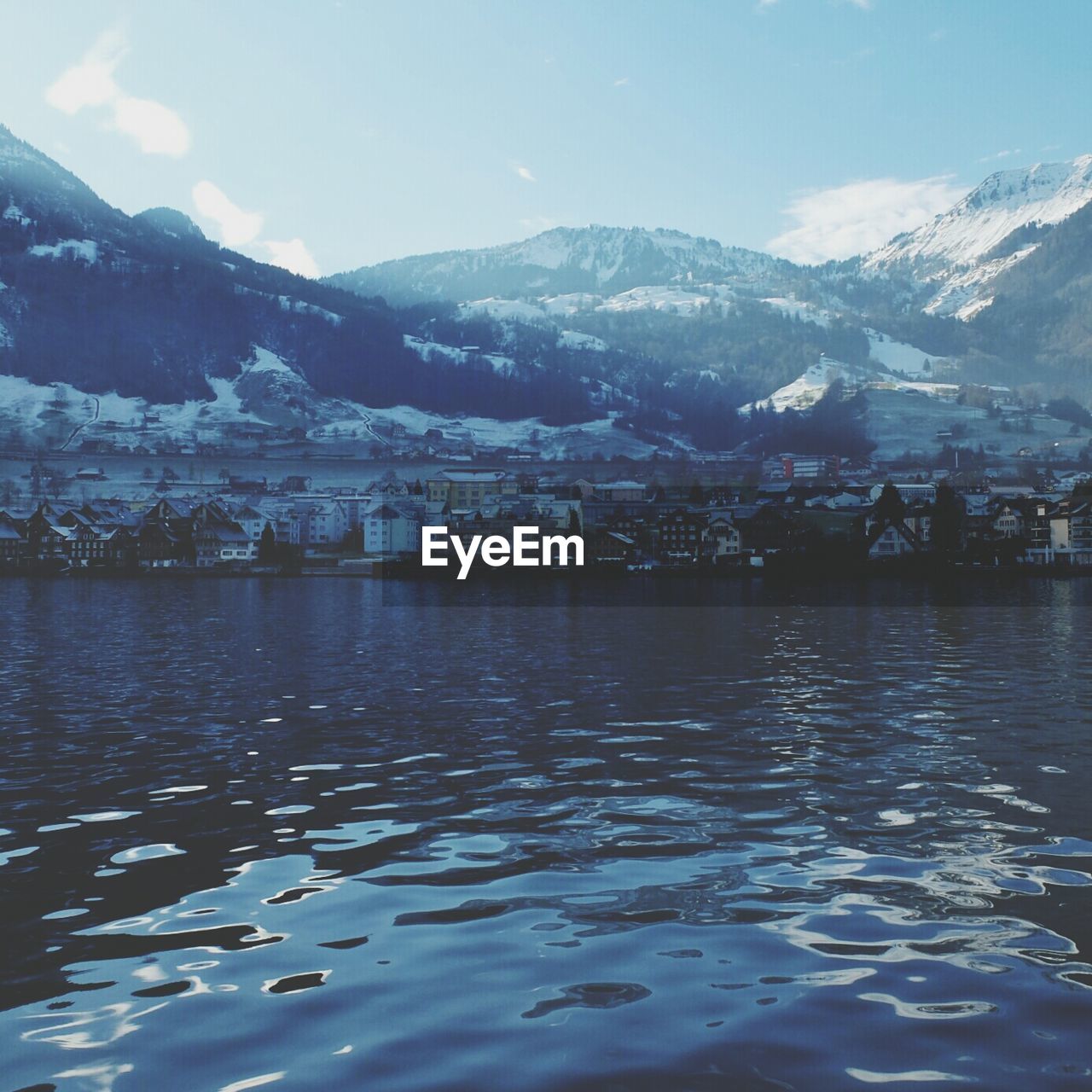 Lake and buildings against mountains