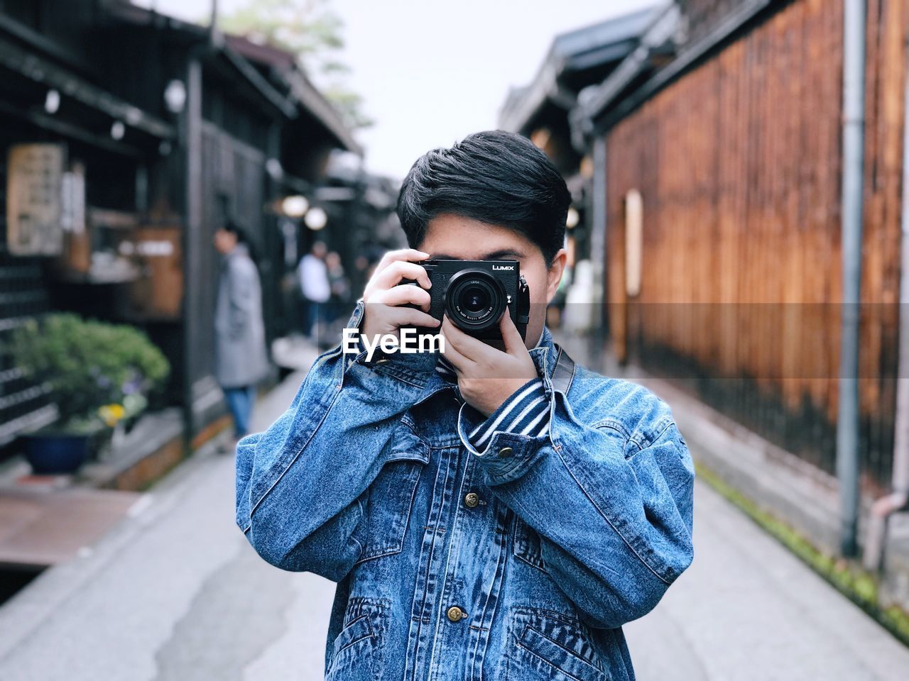 PORTRAIT OF YOUNG MAN PHOTOGRAPHING CAMERA