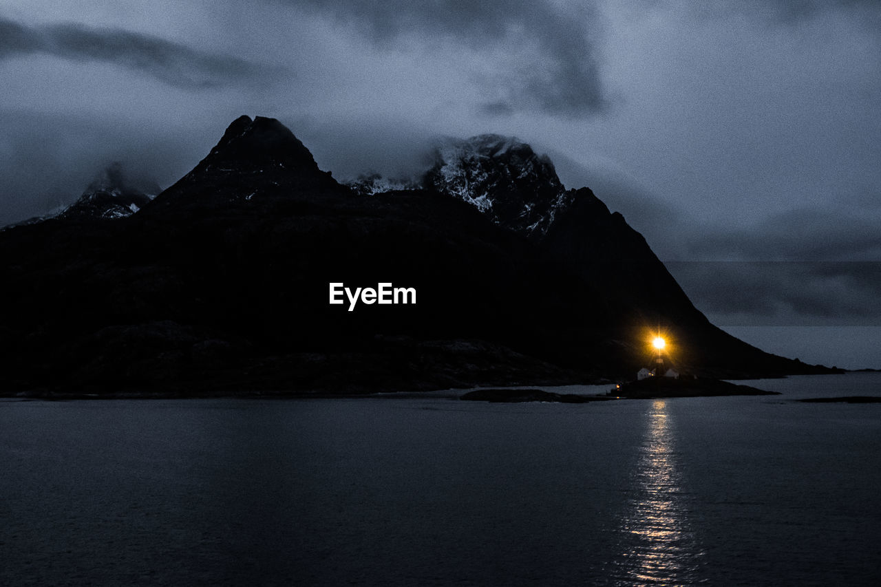 SCENIC VIEW OF SEA AGAINST MOUNTAIN DURING WINTER