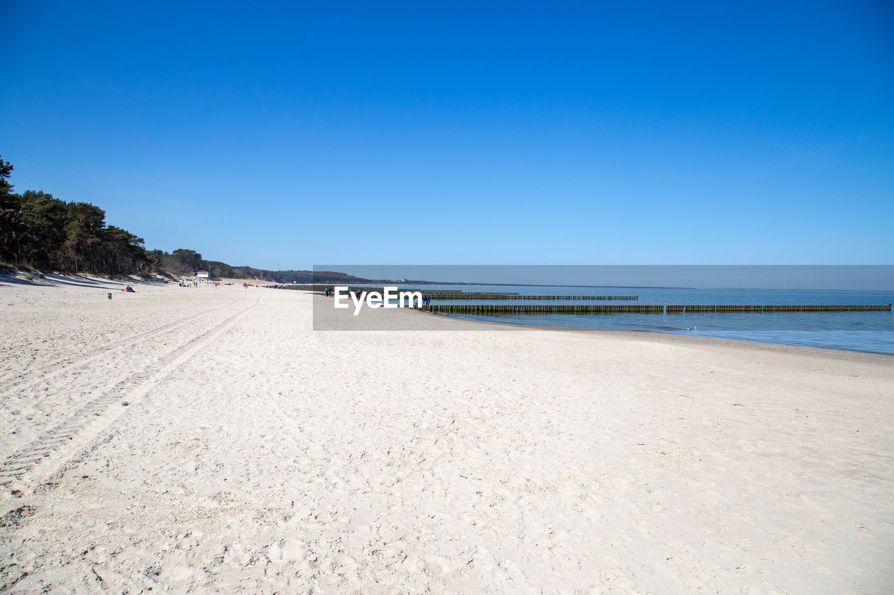 Scenic view of beach against clear blue sky