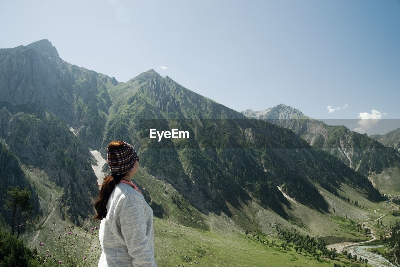 Woman standing on mountain against sky