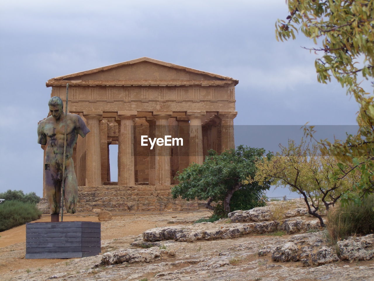 Weathered sculpture in front of temple of concord