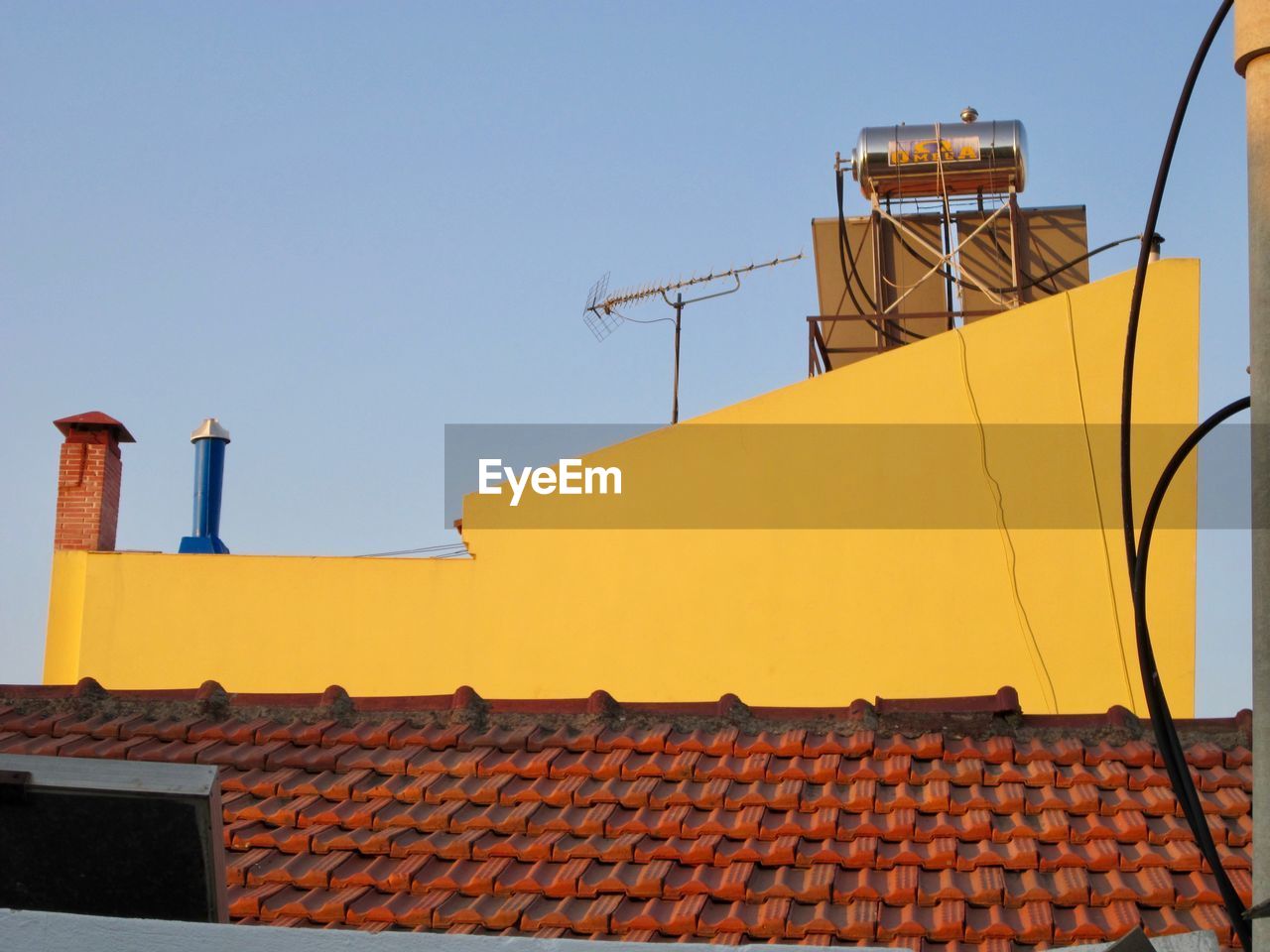 LOW ANGLE VIEW OF YELLOW ROOF AGAINST BUILDING