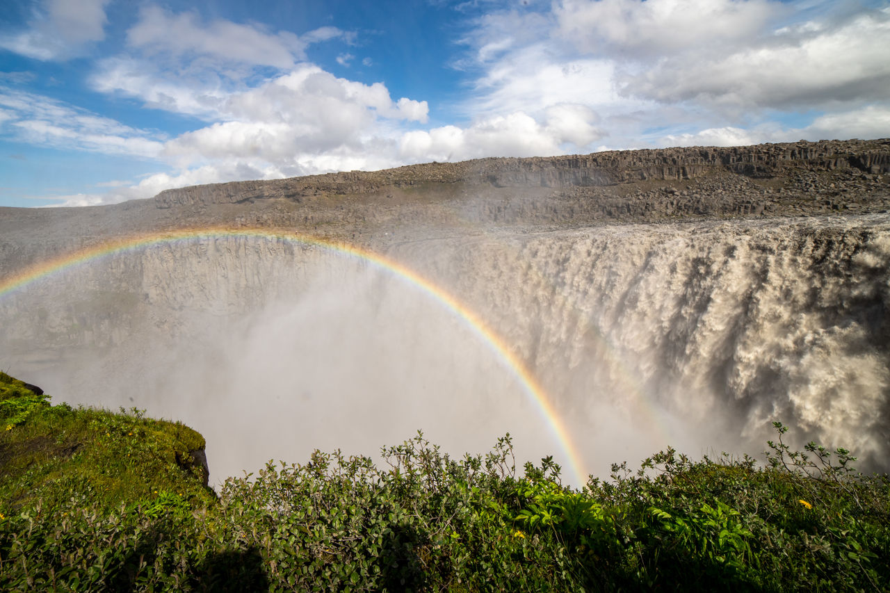 SCENIC VIEW OF RAINBOW OVER LANDSCAPE AGAINST SKY