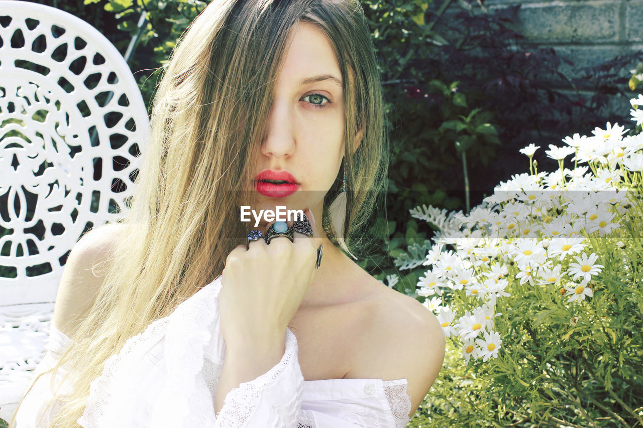 Portrait of beautiful woman against flowering plants