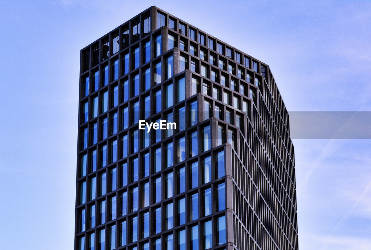 Low angle view of modern building against blue sky