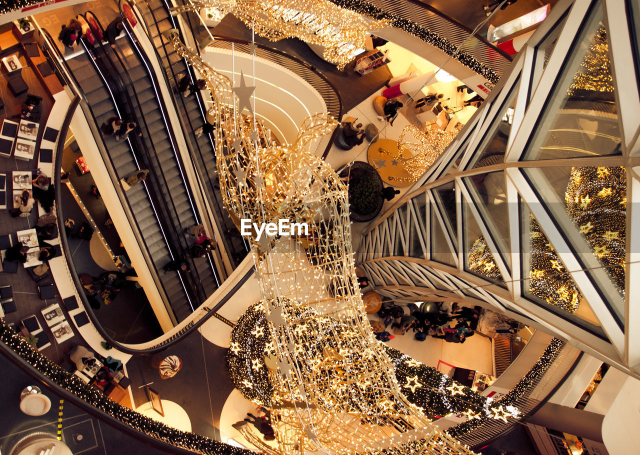 TILT IMAGE OF SHOPPING MALL IN CITY AT NIGHT