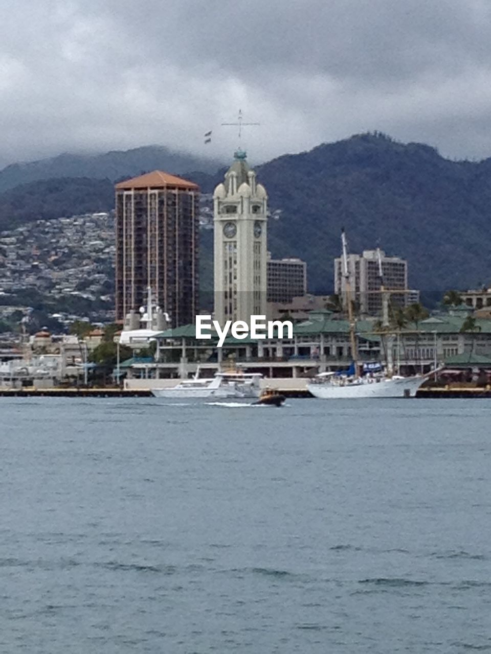 VIEW OF RIVER AND BUILDINGS AGAINST CLOUDY SKY