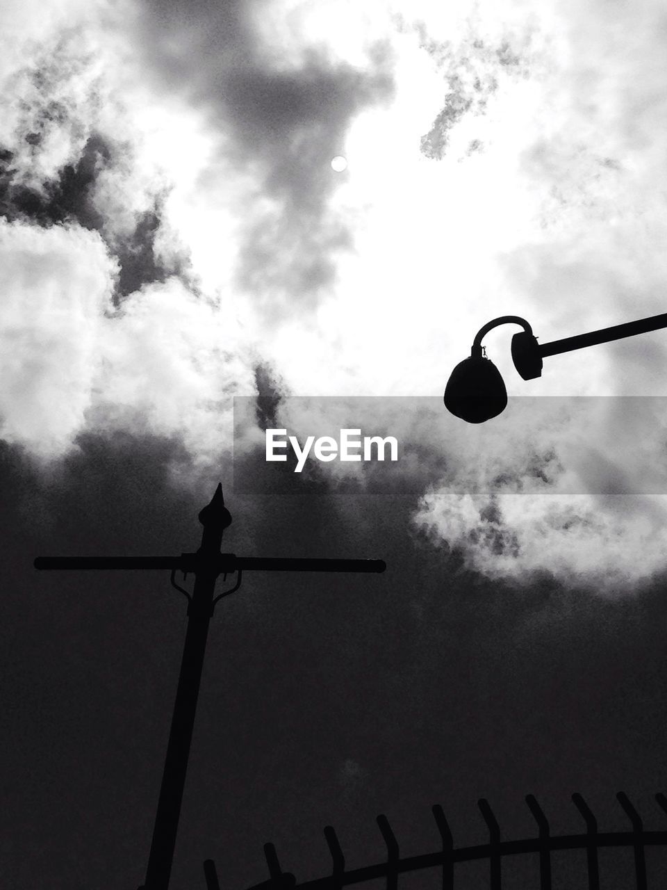 LOW ANGLE VIEW OF STREET LIGHTS AGAINST CLOUDY SKY