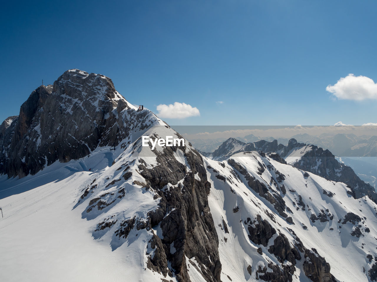 Scenic view of snowcapped mountains against blue sky