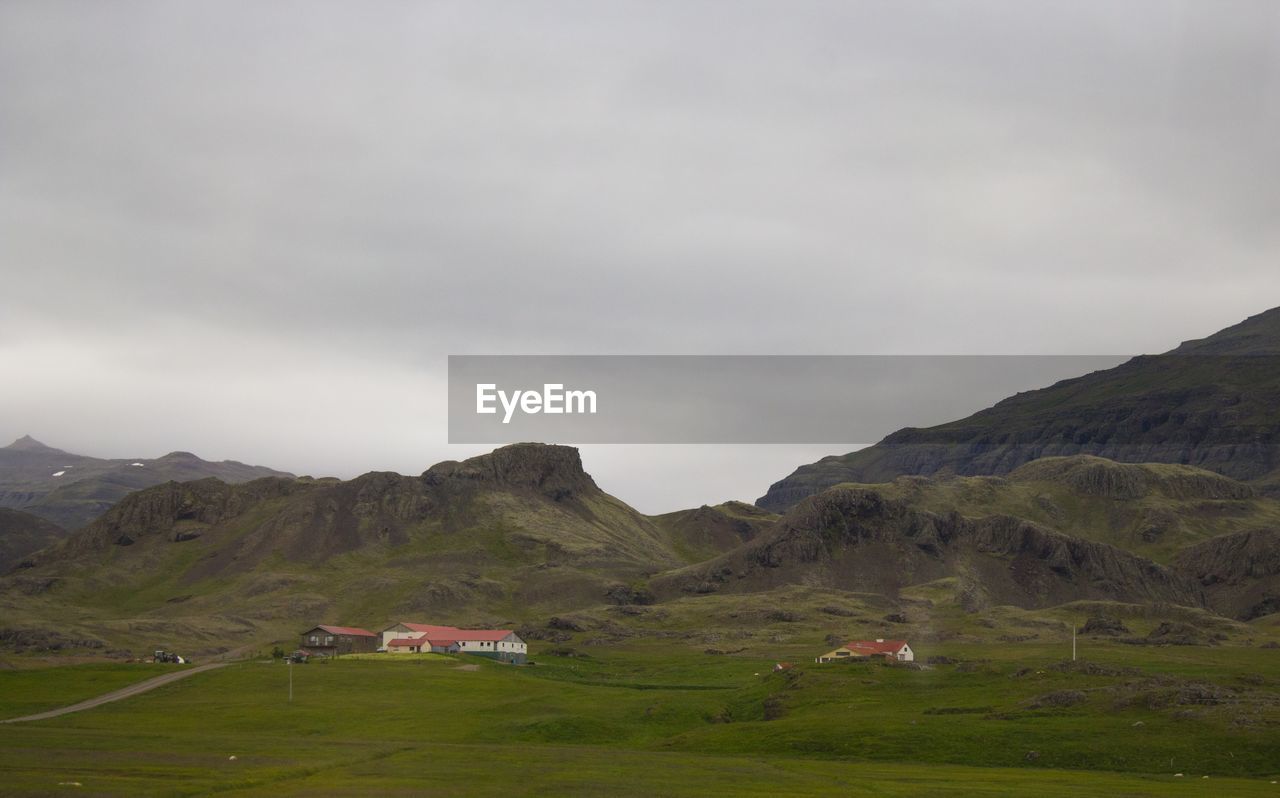 Scenic view of field and mountains against sky
