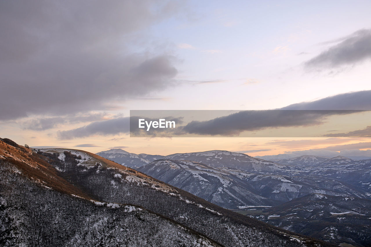 Scenic view of snowcapped mountains against sky during sunset