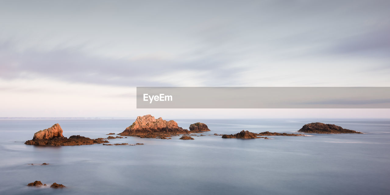 Rocks in sea against sky