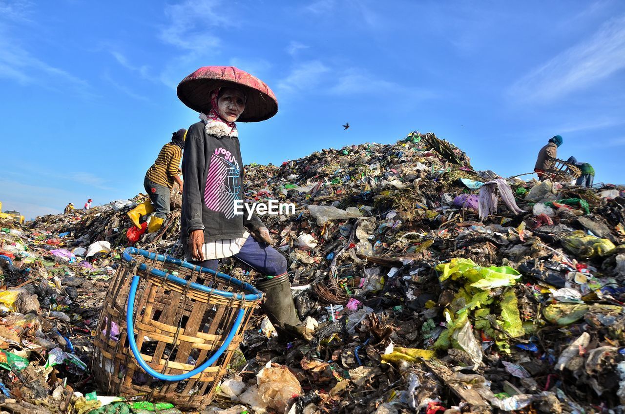 Portrait of woman with basket at scrap yard