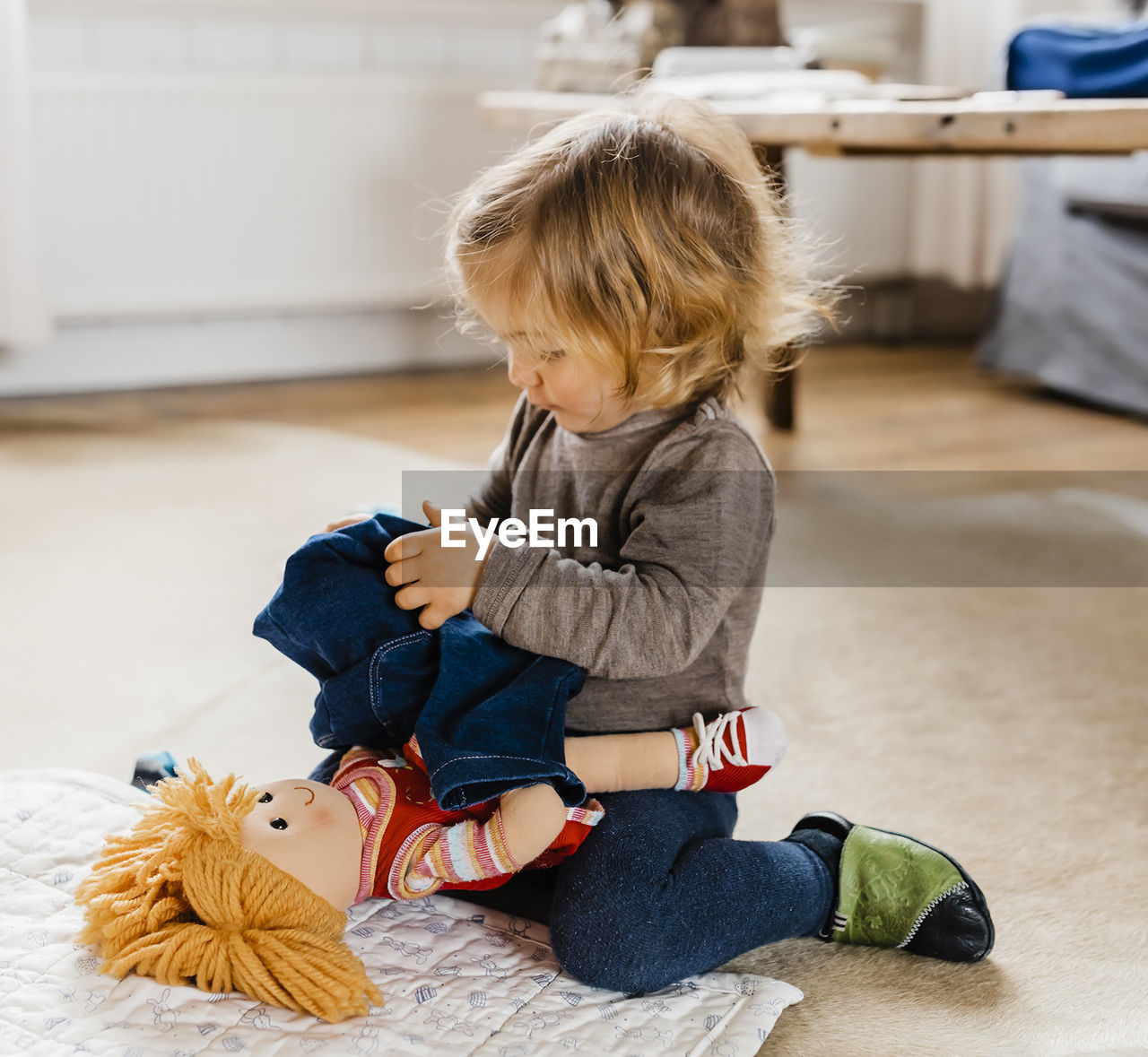 Cute girl sitting on toy at home