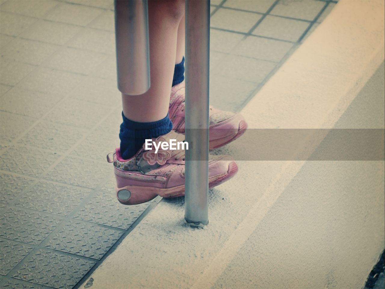 Low section of woman standing on sidewalk