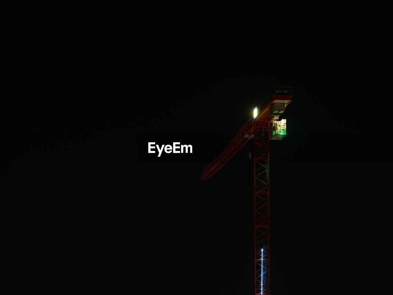 Low angle view of illuminated crane against sky at night