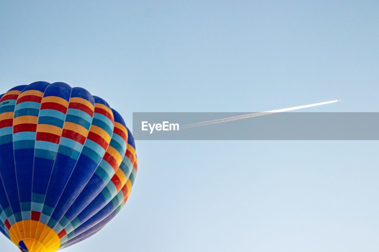 LOW ANGLE VIEW OF BALLOONS FLYING AGAINST BLUE SKY