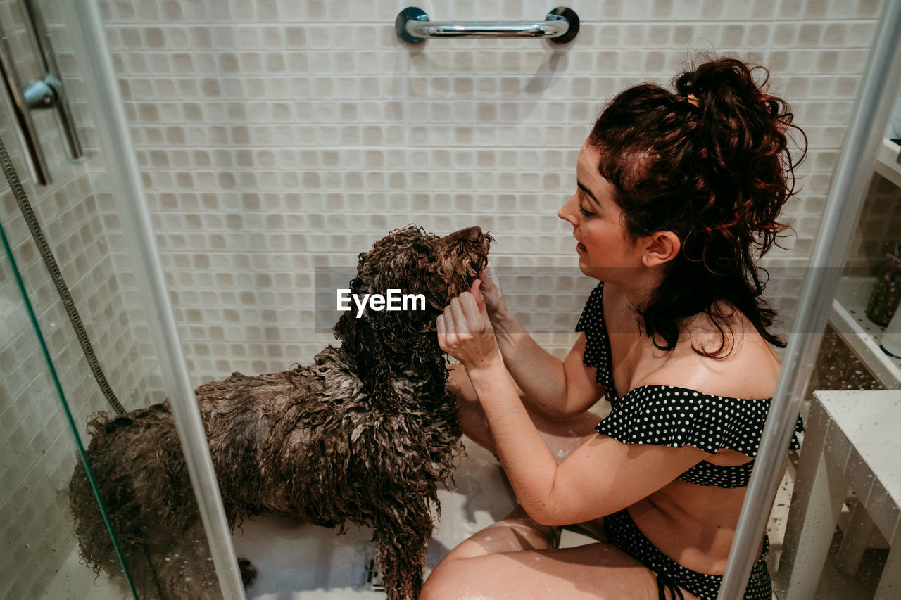 Young woman sitting in bathroom