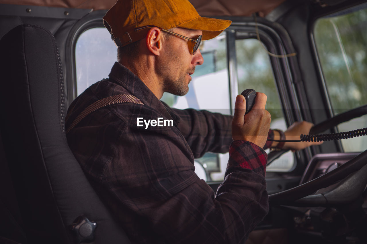 Side view of man sitting in car