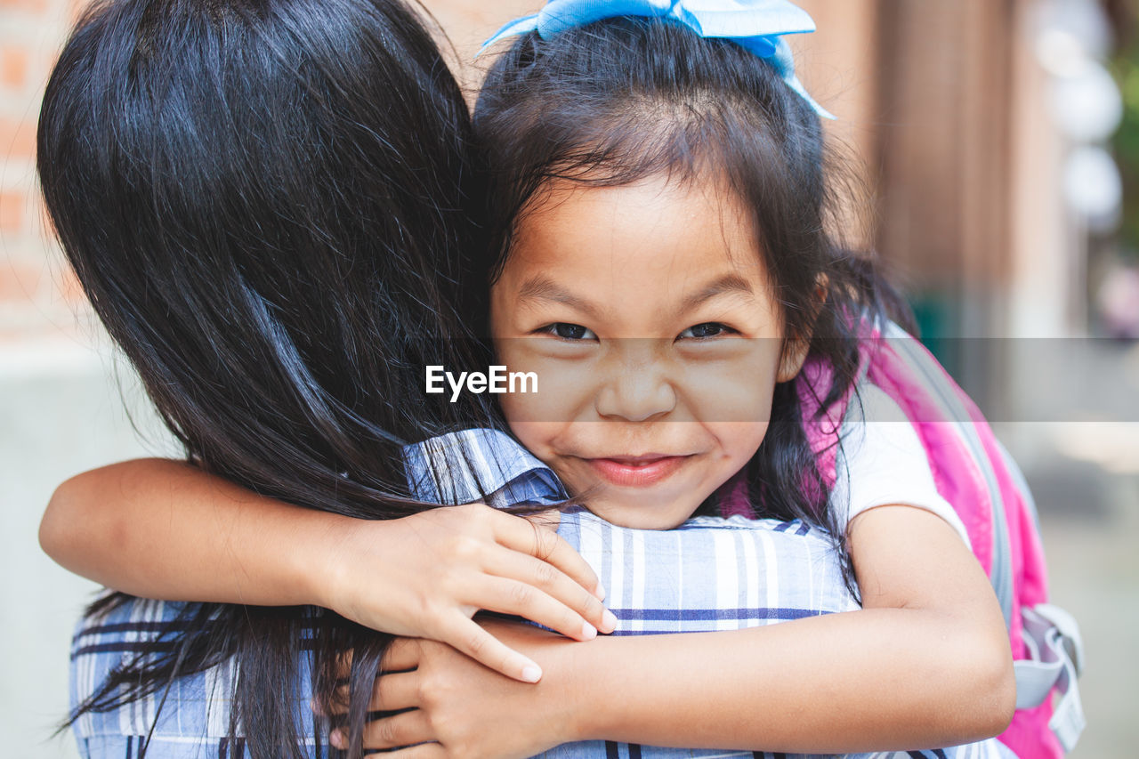 Portrait of girl embracing mother