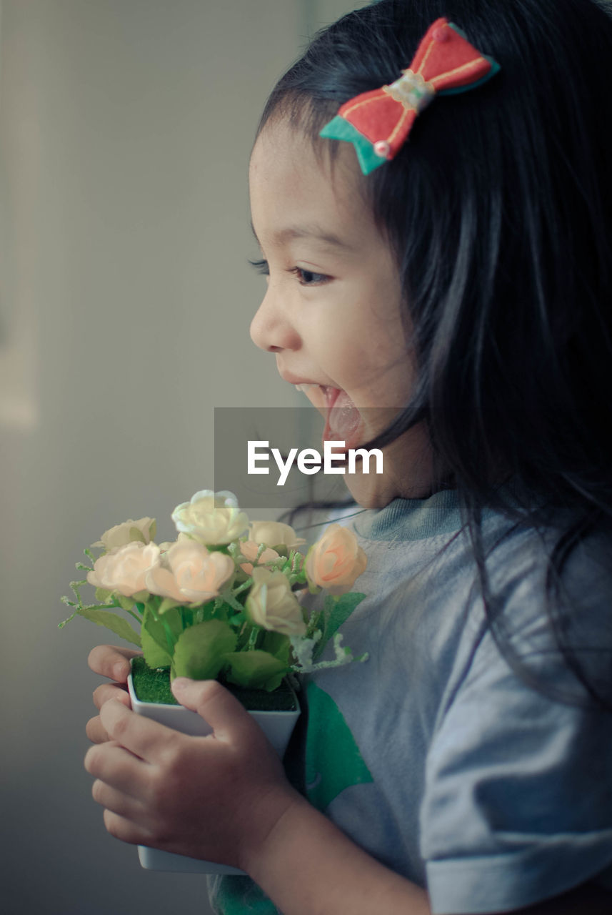 Cheerful girl holding flower 